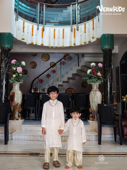 Twinning in timeless white kurta sets. This photo of two brothers showcases our ability to create coordinated, custom-made outfits that are both elegant and comfortable for any occasion.