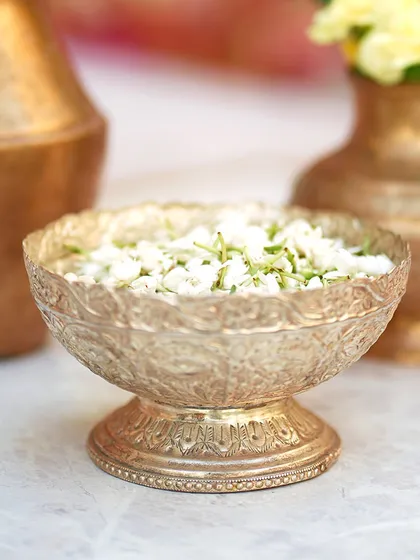 An ornate silver bowl holding fresh jasmine flowers for the ceremony. These small details contribute to a rich and authentic cultural experience.