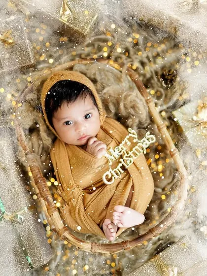 A "Merry Christmas" wish from this precious newborn. Wrapped in a warm golden swaddle and nestled in a basket, this portrait is perfect for a holiday announcement card.