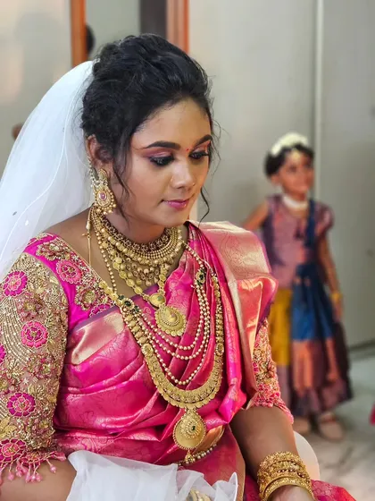 A unique Christian wedding look where the bride paired a traditional pink Kanjivaram saree with a white veil.