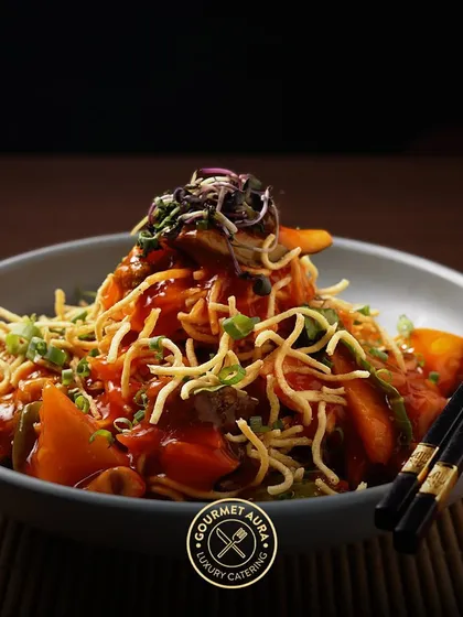 A bowl of American chop suey with crispy noodles and a sweet and tangy vegetable sauce. A nostalgic and satisfying dish that we expertly prepare.