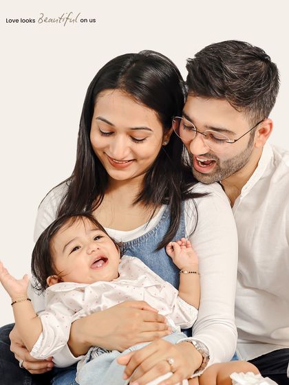 Love looks beautiful on this family. This candid shot captures a moment of pure laughter and joy between the parents and their baby.