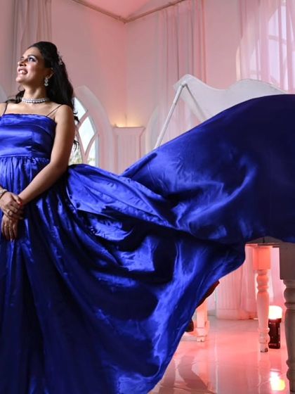 Feel like royalty in this shimmering royal blue satin gown. The extra-long trail drapes beautifully, creating a rich, luxurious look that's perfect for an elegant indoor shoot.