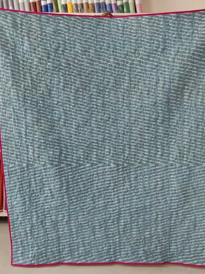 The back of the jelly roll quilt, with a simple striped fabric.