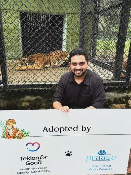 Our work extends to all animals. Here, Ani is pictured with a tiger adopted through our foundation's efforts. We love, protect, and conserve all life.