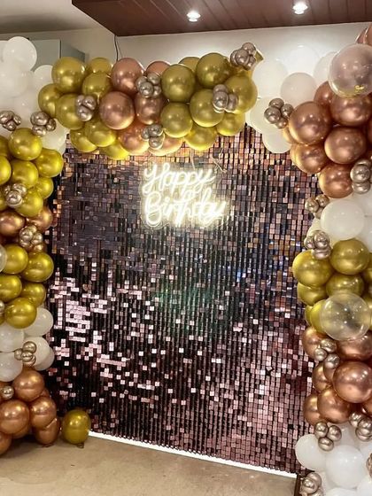 A close-up of the balloon arrangement framing the sequin wall. I mix in transparent balloons and different metallic shades to create a more sophisticated look. This entire backdrop, including the neon sign, is part of my party decoration packages.
