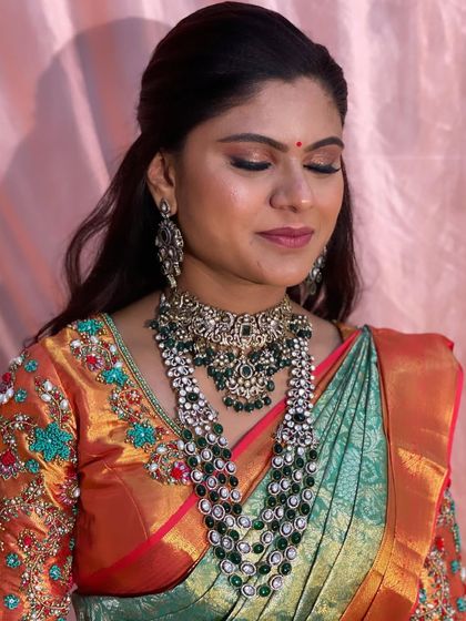 A close-up of Swathi's makeup, featuring warm, earthy tones on the eyes and a soft nude lip to balance the grandeur of her jewellery.