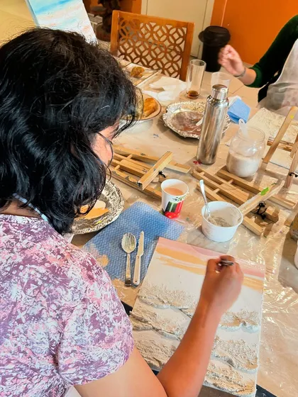 Ride the waves of life. A participant at one of our art workshops, finding focus and motivation through the creative process of painting.