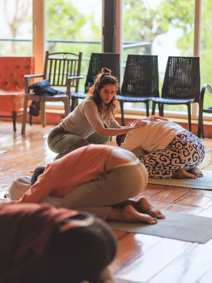 Providing a gentle assist in Balasana (Child's Pose). This posture is a return to the self, a moment to rest and reconnect with the breath.