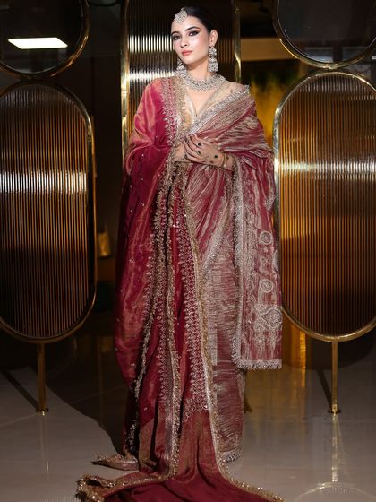 A full-length view of this royal bride. The rich velvet shawl and intricate embroidery are complemented by a classic makeup look.