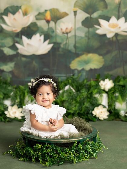 A classic sitter session portrait. This little girl looks so sweet and content sitting in a basket against the beautiful lotus pond backdrop.