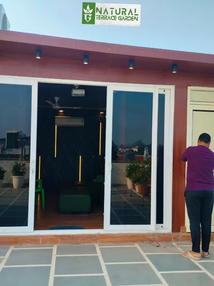 The exterior view of the compact terrace room, showing its sliding glass doors and how it integrates with the existing building structure.