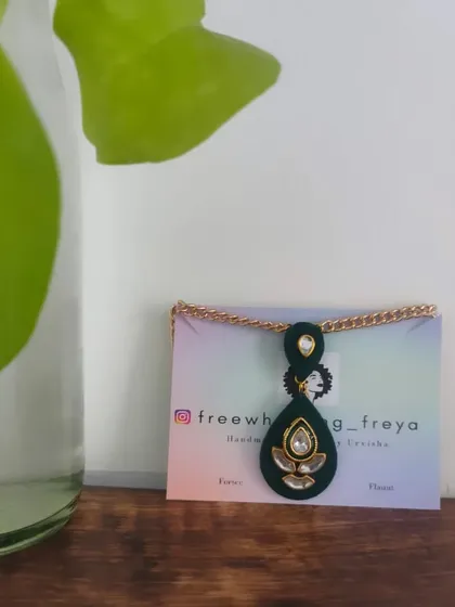 This dark green teardrop pendant necklace is a versatile piece for any occasion. It features delicate Kundan work and can be styled with both casual and formal wear.