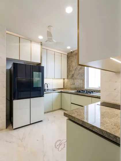 This wide shot showcases the L-shaped kitchen layout with its smart refrigerator and ample counter space. The under-cabinet lighting provides excellent task lighting while adding to the ambient glow.
