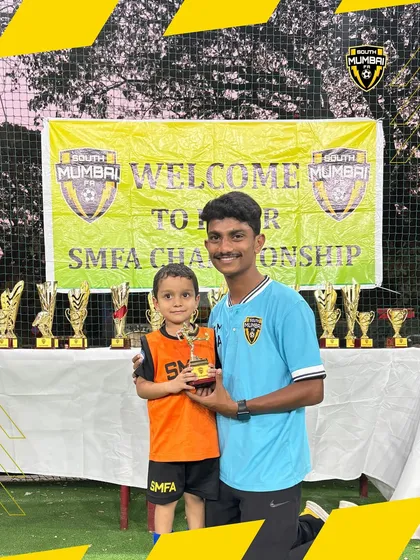 A coach presenting a trophy to one of our youngest players. We celebrate every child's effort and participation.