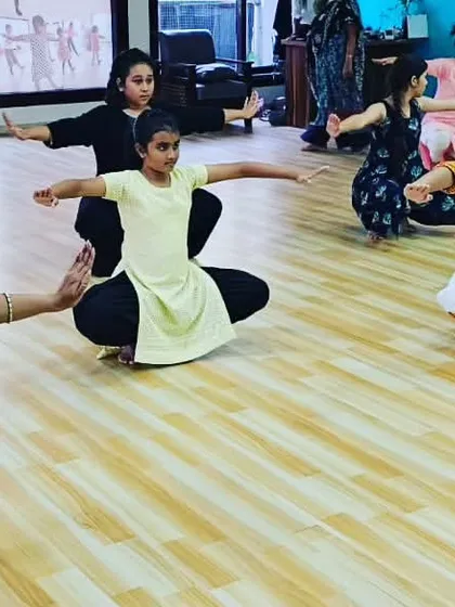 A close-up of the students in the 'Araimandi' posture. This foundational pose strengthens the core and legs, which is essential for a Bharatanatyam dancer.