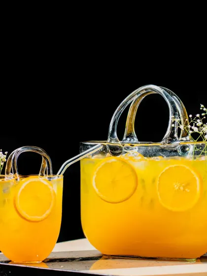 We believe a cocktail should be a piece of art. This custom drink, served in a unique handbag-shaped glass pitcher and cup, shows our commitment to creative presentation and detail.