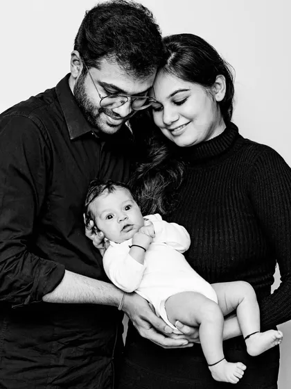 The first family portrait. This black and white lifestyle photo shows new parents lovingly holding their newborn. These sessions are all about capturing the cuddles, the tiny features, and the overwhelming joy of this new chapter in your lives.