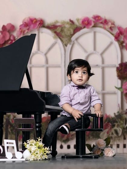 Their innocence fills my heart with warmth. A boy in a bow tie sits at the piano in our beautiful floral-themed studio.