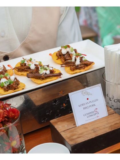 A close up of our Korean Pulled BBQ Pork canapés, showing the texture of the tender pork and the fresh garnish. This dish is a testament to our innovative and globally inspired menu.