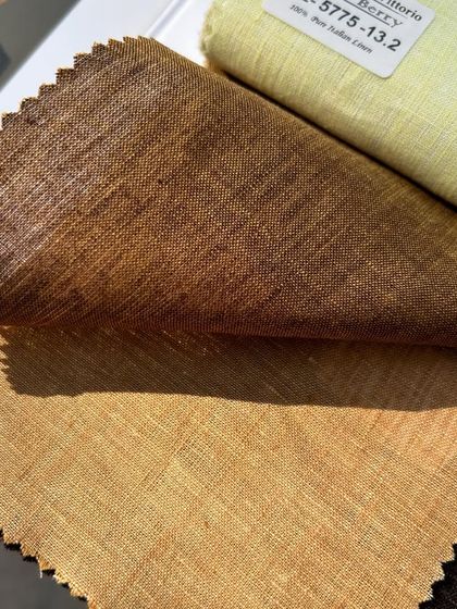 Swatches of pure Italian linen in earthy tones of brown and green, ideal for a refined summer wardrobe.
