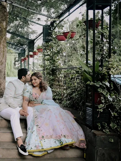 An intimate moment on the steps of their engagement venue. The groom's gentle kiss on the bride's forehead is a perfect, tender memory to capture.
