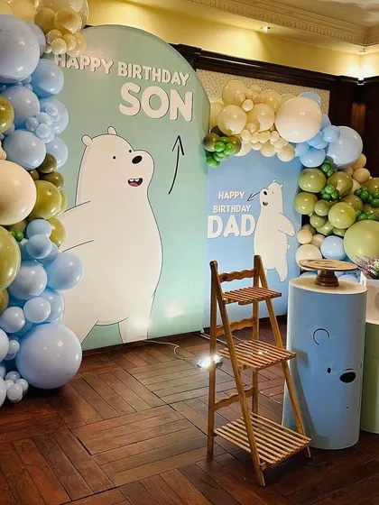 A full view of the "We Bare Bears" birthday decor, showing the two backdrops and the complete balloon arch. The wooden ladder shelf adds a rustic touch and a place for additional displays.