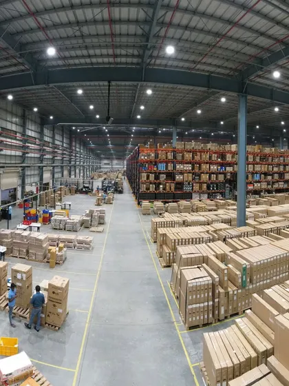A panoramic shot of a massive Croma warehouse in Bangalore, showing the vast scale of the logistics operation. The aisles are filled with neatly organized boxes and shelves, highlighting efficiency and order.