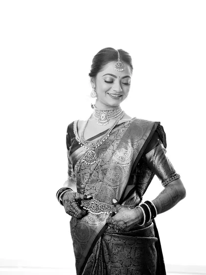 A high-contrast black and white portrait of the bride, Aditi, showcasing her elegance and the beautiful details of her Kanjivaram saree.