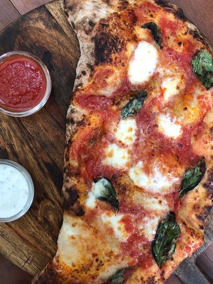 Our half-moon calzone, stuffed with cheese and toppings, then baked until golden. It's served with our classic tomato sauce and a creamy dip on the side.