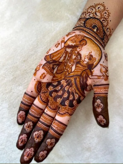 A complete bridal hand featuring Radha and Krishna under the full moon. The dark shading and intricate patterns on the fingers create a beautiful contrast.