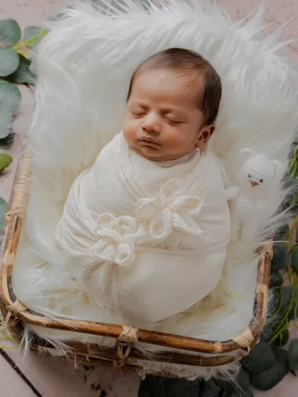 An example of a rustic, natural setup using a wicker basket, white fur, and eucalyptus leaves. This style focuses on texture and earthy tones for a timeless look.