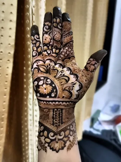 The same design on the palm. The pattern continues with a central floral mandala, creating a cohesive look from front to back.