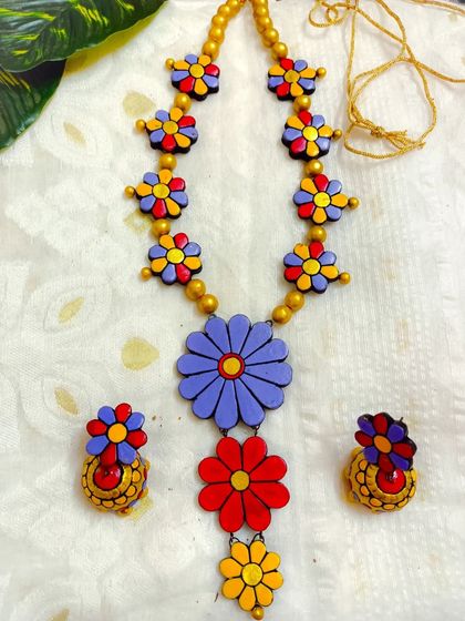 A vibrant, multi-colored version of the long floral necklace, featuring purple, red, and yellow flowers. This piece is a true celebration of color.