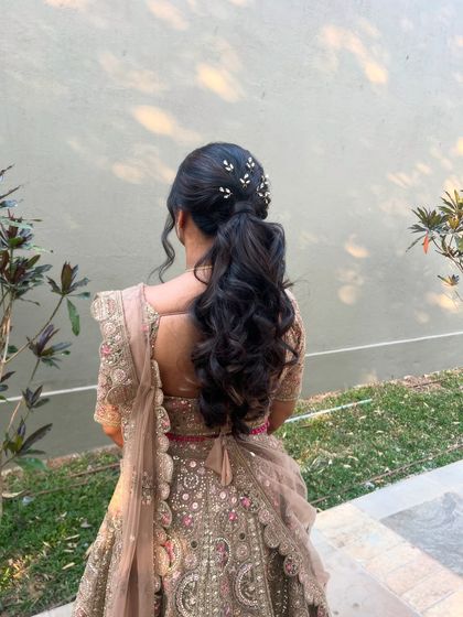 The full look of the bride in her lehenga, her elegant ponytail completing the ensemble.