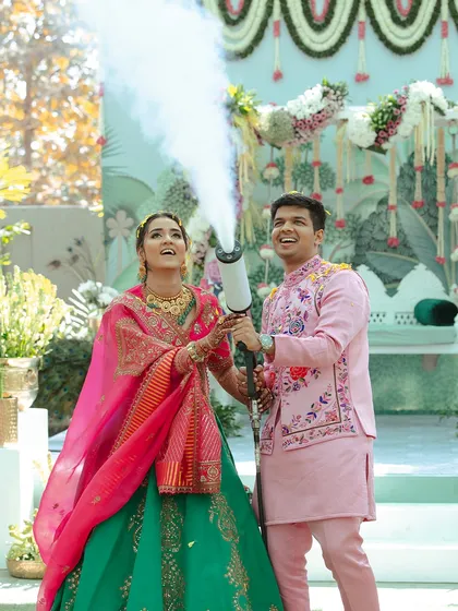 A fun and candid shot of the couple playing with a CO2 gun during their Haldi. It's important to capture the playful side of your relationship too.