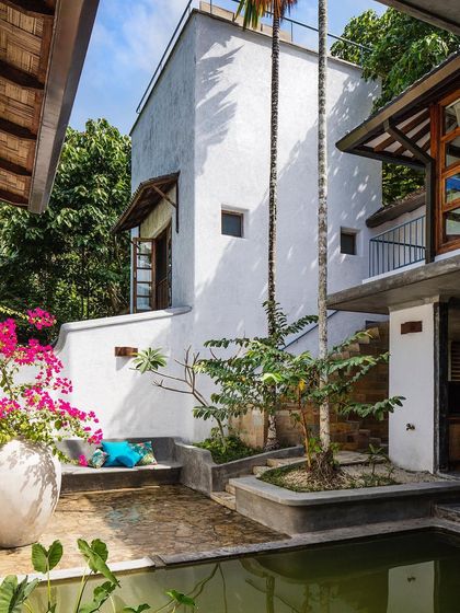 The main villa's courtyard, a multi-level space designed around existing trees and a central water body.
