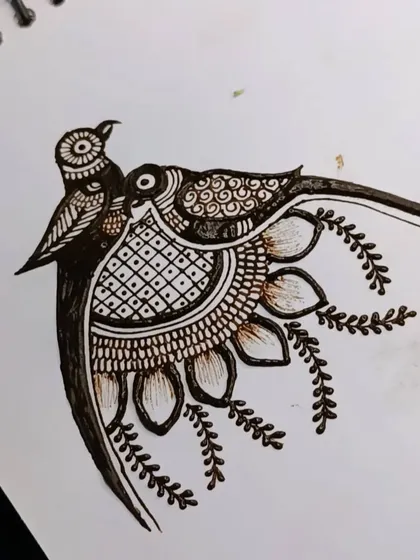 The completed lovebird design, now filled with detailed patterns and surrounded by delicate leaves. This can be placed on the palm or as part of an arm band.