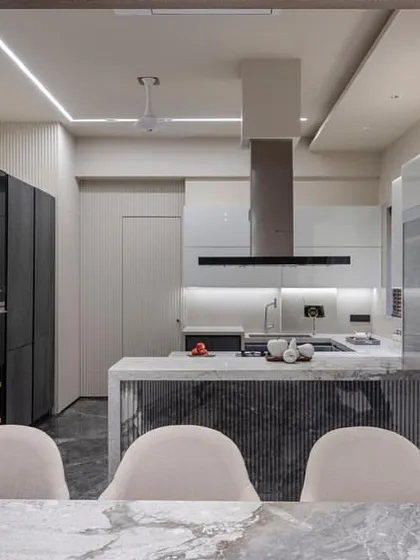 The kitchen as seen from the dining table, emphasizing its role as the heart of the home. The consistent color and material palette creates a cohesive look.