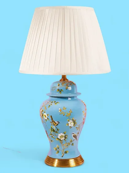 A lovely sky blue base with painted birds and flowers gives this lamp a light and airy feel. It's a wonderful piece for bringing a touch of nature-inspired beauty indoors.