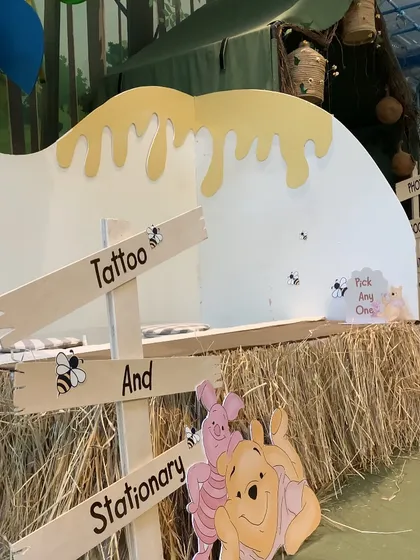 A "Tattoo and Stationery" stall at the Winnie the Pooh party, offering themed activities and take-home goodies for the guests.