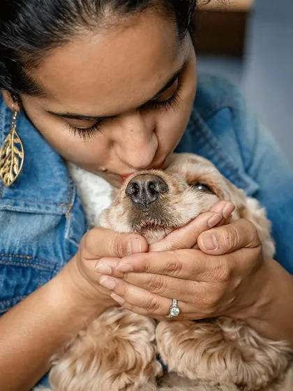 A close-up of a woman kissing her cocker spaniel, Zoey. This shot is filled with emotion and shows the pure love between a pet parent and her furry child.