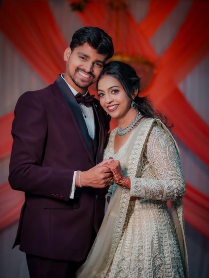 A classic portrait of the newly engaged couple. They stand together, holding hands and smiling at the camera, capturing the happiness of their formal commitment.