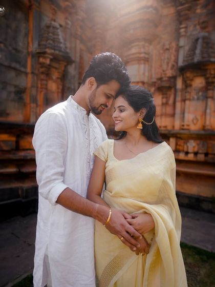 A classic romantic portrait against the warm, sunlit stone of the temple. The golden hour light adds a magical glow to this pre-wedding photo.