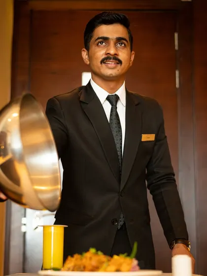 A photograph capturing the warm hospitality and excellent service at Courtyard by Marriott. This image was created to highlight the in-room dining experience for their marketing materials.