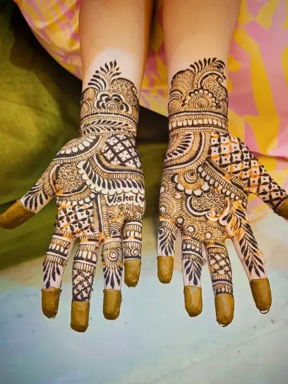 A custom design with the name "Vishal" beautifully written into the palm, surrounded by a mix of checks, curves, and floral elements.