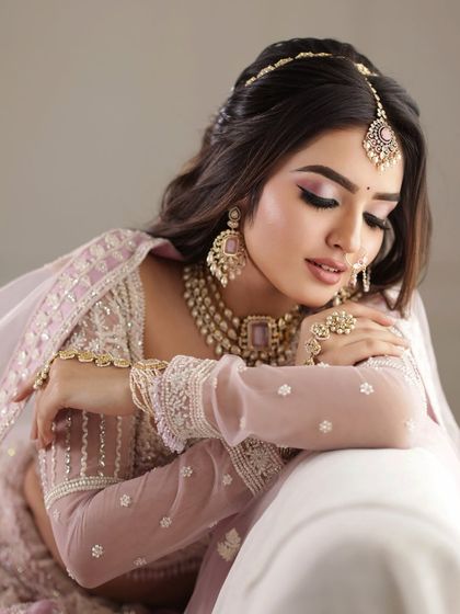 An elegant, eyes-closed portrait that focuses on the delicate details of the makeup and jewelry.