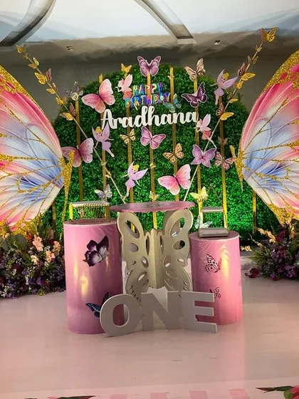 This butterfly theme is a great example of combining different elements for a magical effect. I used a lush green wall, custom butterfly wing props, and themed cake plinths to create an enchanted garden feel.