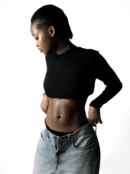 A profile shot that highlights the model's features and the simple, chic styling. The clean lighting and background keep the focus entirely on the subject and the product.