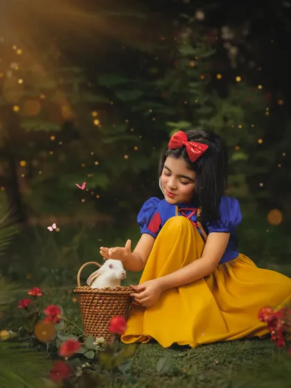 In a magical forest clearing, our Snow White gently pets a soft white bunny. I love incorporating live animals safely into shoots to bring an extra layer of wonder and authenticity.